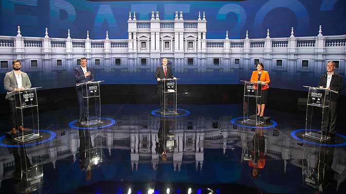 Candidatos presidenciales en el debate. Cada uno está detrás de un podio y hay distancia entre ellos. De izquierda a derecha: Gabriel Boric, Sebastián Sichel, José Antonio Kast, Yasna Provoste y Eduardo Artés.