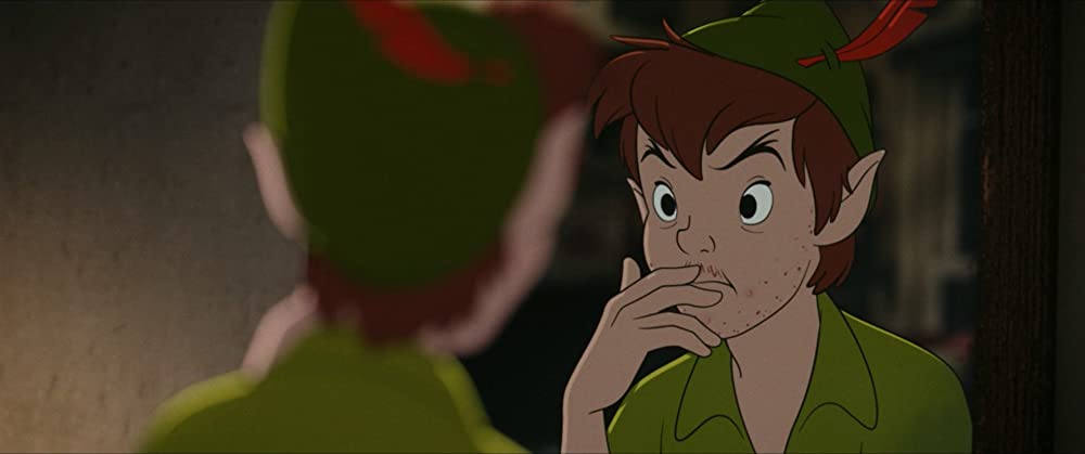 Peter Pan frente a un espejo, sin rasurar su barba de adolescente