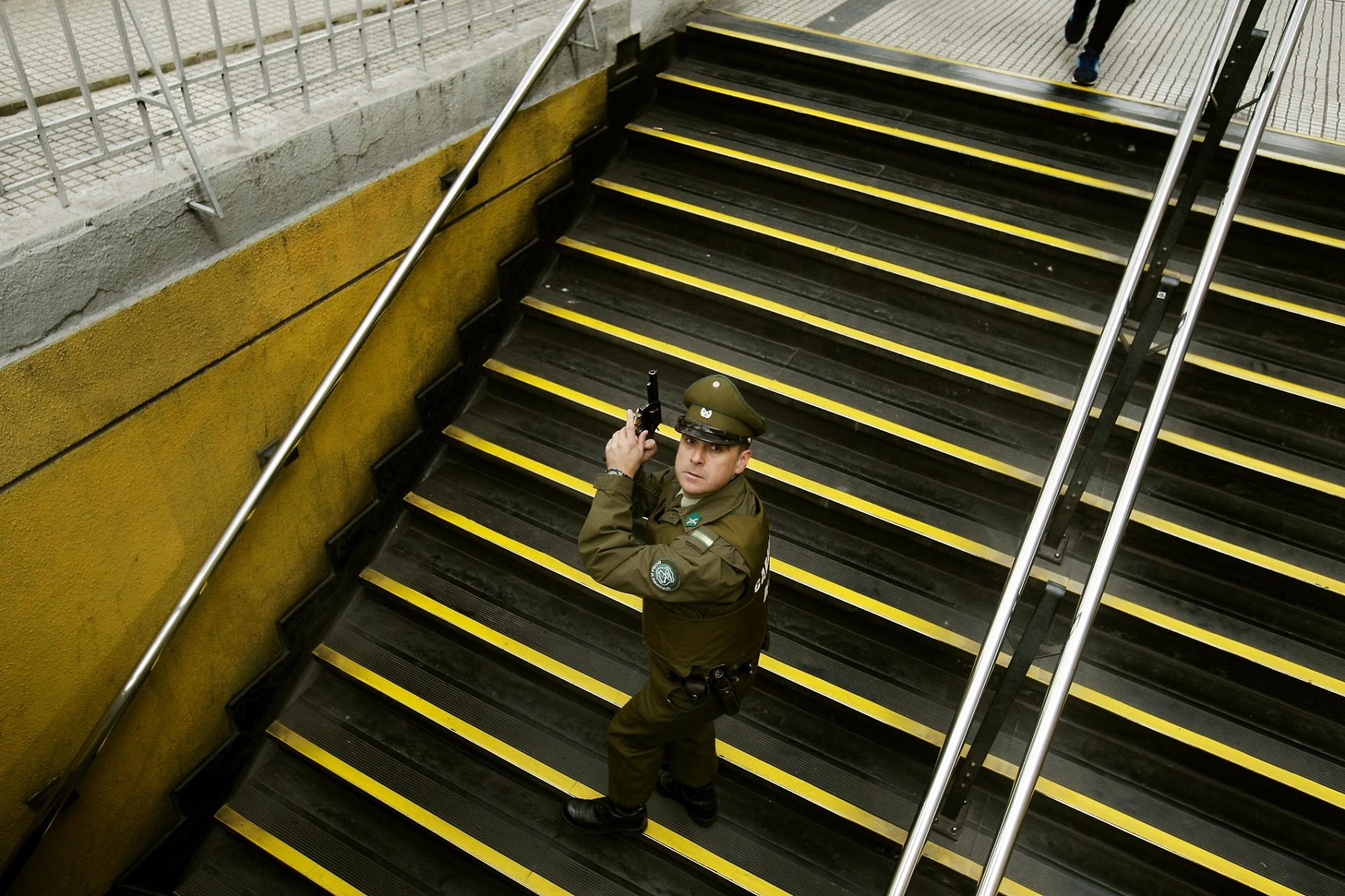 Carabinero portando su arma de servicio en metro Los Héroes en marcha estudiantil.