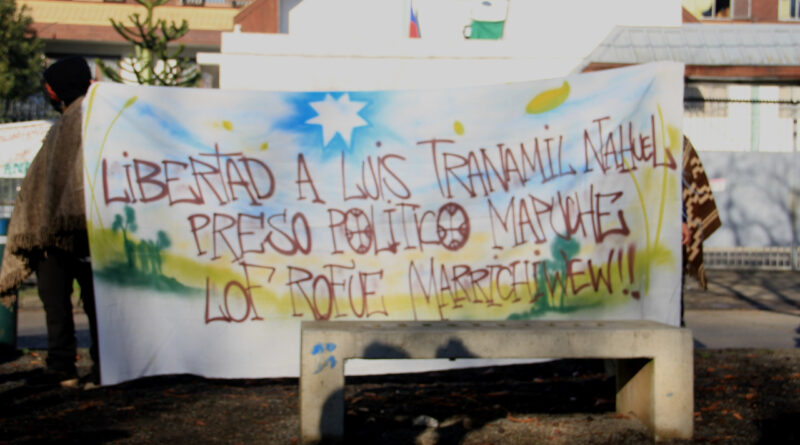 Imagen con lienzo que dice “Libertad a Luis Tranamil, preso político mapuche, lof rofue”