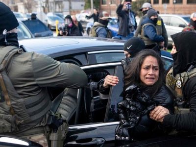 Policias de ICE llevandose a una mujer encarcelada